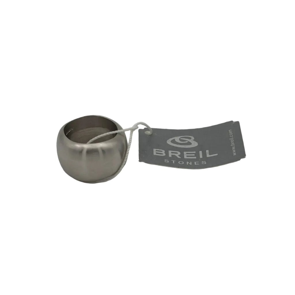 Anello a fascia bombata Breil Stones in acciaio satinato. La prospettiva mette in risalto il design volumetrico e la finitura del metallo, accompagnato dall'etichetta originale del brand con cordoncino bianco.