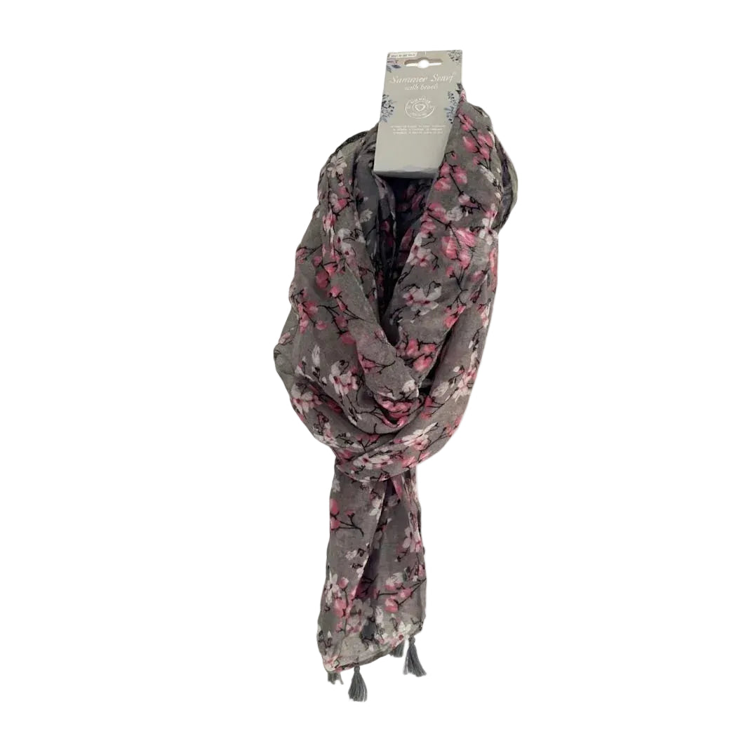 Sciarpa estiva grigia con stampa a rami di fiori rosa e bianchi e piccole nappe grigie.