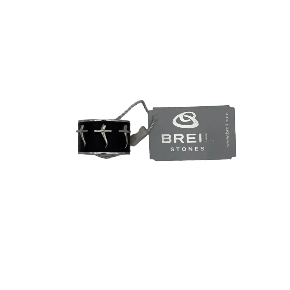 Primo piano di un anello da uomo Breil Stones. Il gioiello presenta una fascia centrale in ecopelle o texture nido d'ape color nero, decorata con tre croci stilizzate. La montatura è in acciaio color argento. A lato, l'etichetta originale Breil Stones grigia su sfondo bianco. 