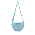 Borsa a tracolla azzurra a mezzaluna in tessuto tecnico, vista frontale con cerniera superiore e tracolla regolabile.