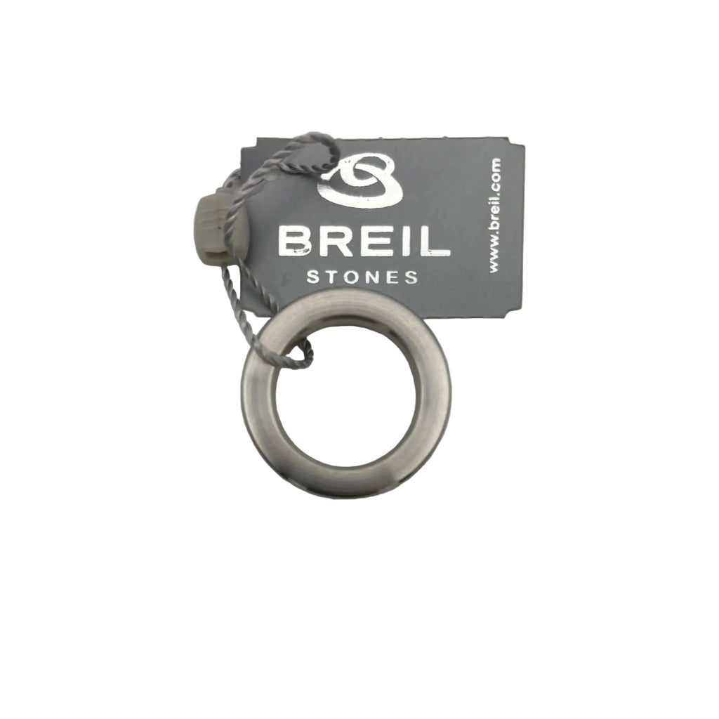 Vista ravvicinata dell'anello/ciondolo Breil Stones in acciaio . L'immagine si concentra sull'etichetta grigia con il logo Breil e la scritta 'STONES', e sul cordoncino grigio intrecciato a cui è fissato. Design minimalista a fascia piatta.