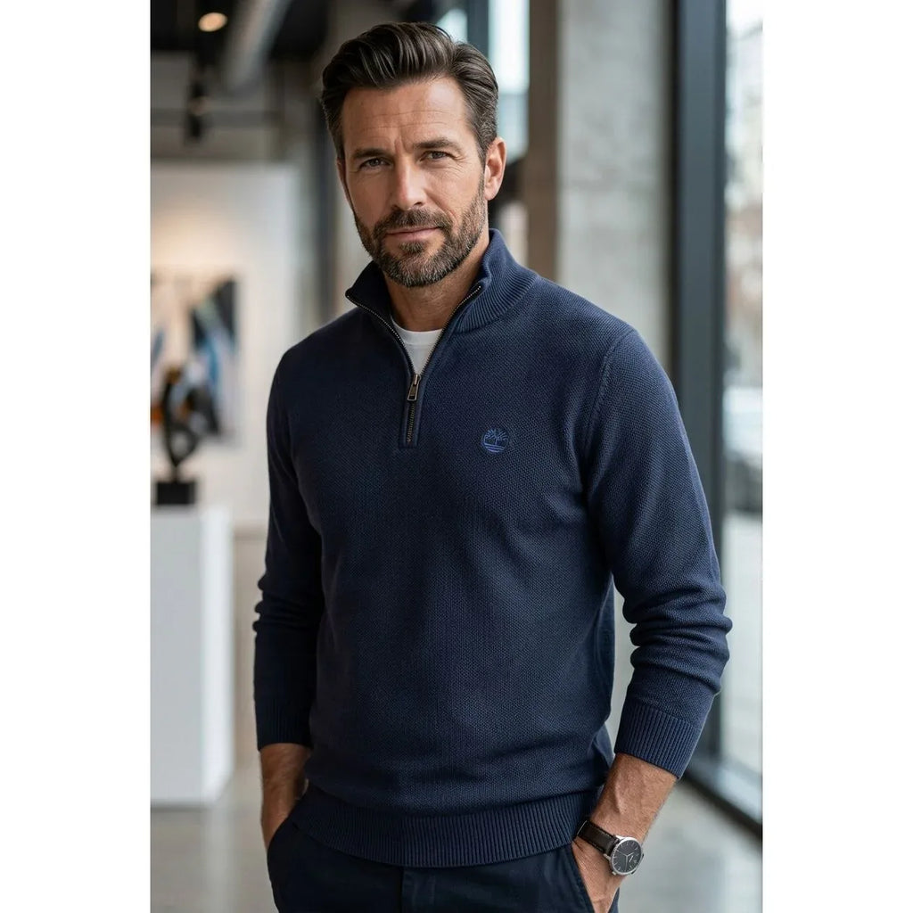 Modello che indossa il maglione blu scuro Timberland con mezza zip aperta. La foto evidenzia la vestibilità moderna e la texture del tessuto a maglia.