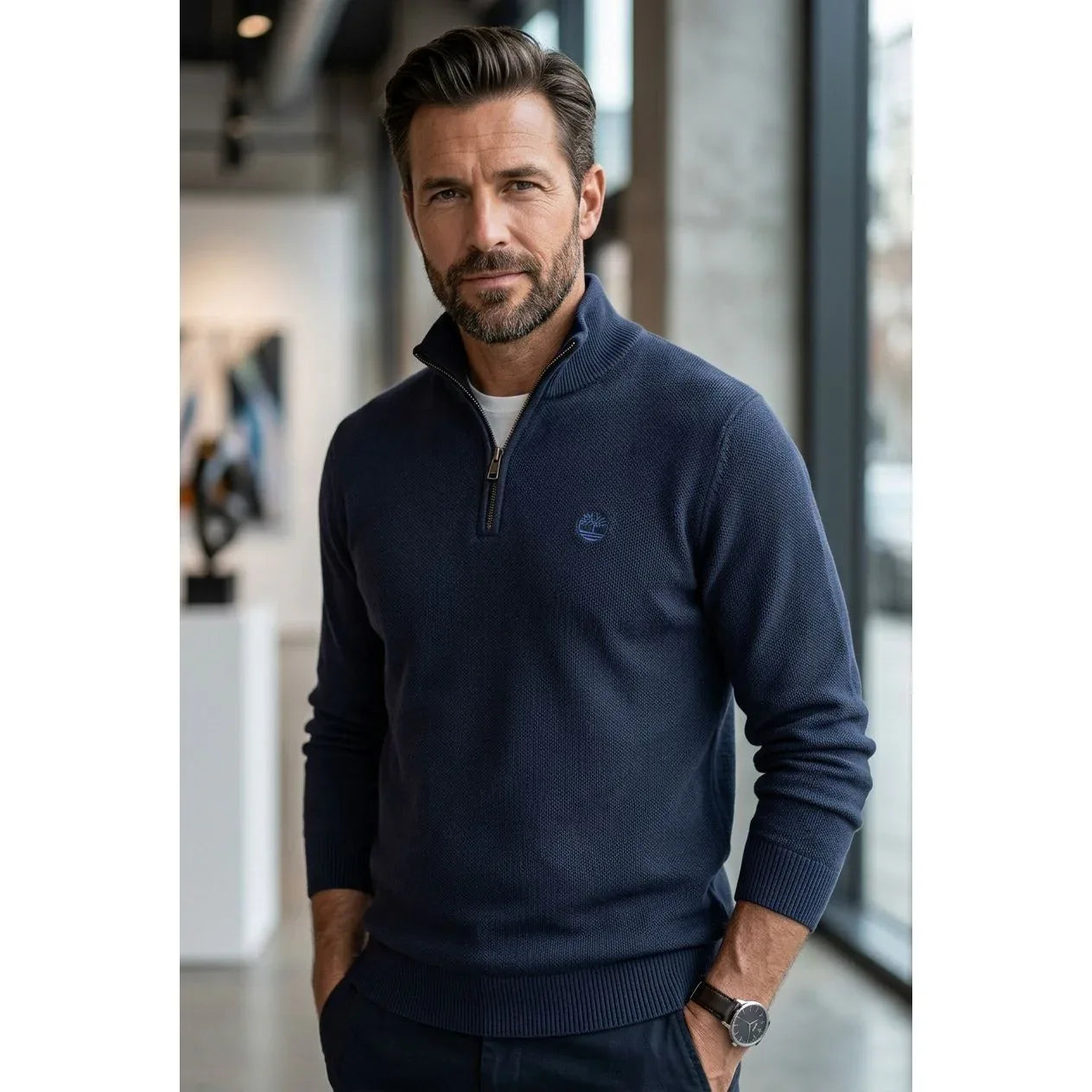 Modello che indossa il maglione blu scuro Timberland con mezza zip aperta. La foto evidenzia la vestibilità moderna e la texture del tessuto a maglia.