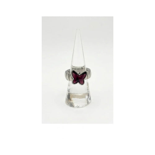 Anello a fascia elastica in metallo argentato con farfalla in cristallo viola ametista, esposto verticalmente su un supporto a cono trasparente su sfondo bianco uniforme.